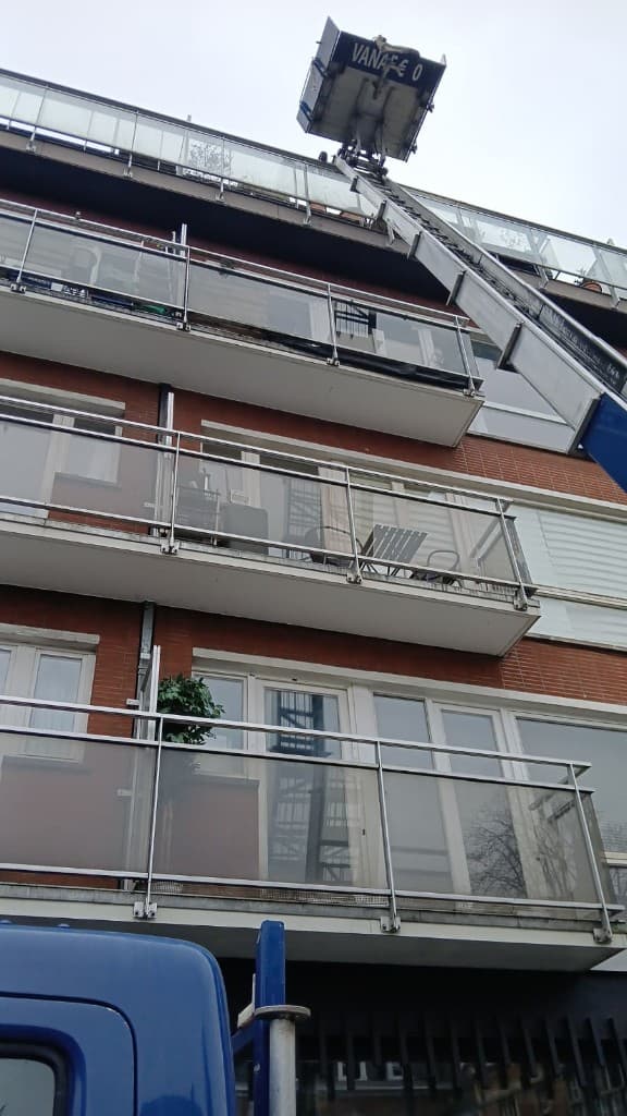 Monte-meuble déployé jusqu'à un balcon en hauteur — immeuble en briques à Bruxelles
